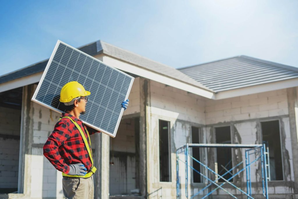 Instalador de Enérgica Renovables esta preparado para instalar unos paneles solares sobre el tejado de una vivienda unifamiliar durante su construcción.